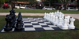Um jogo de esportes um grande tabuleiro de xadrez e peças de plástico  close-up de grandes peças brancas e um xadrez gigante